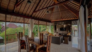 A spacious indoor area with a high ceiling, wooden furniture, and a large TV screen. - Campania Villa Bali (Sukawati)