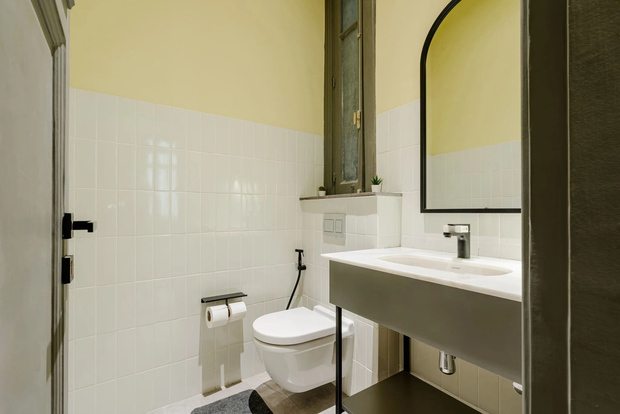 Une salle de bain avec des toilettes, un lavabo et un miroir.