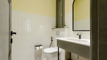 Une salle de bain avec des toilettes, un lavabo et un miroir.