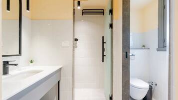 Un baño moderno con ducha, inodoro y lavamanos.