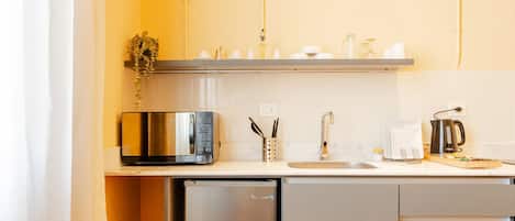 A compact kitchen with a microwave, sink, and coffee maker.