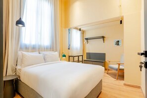 A hotel room with a bed, a TV, a chair, and a desk. - Studio Apartments Downtown Alexandria Menascehouse (Alexandria)