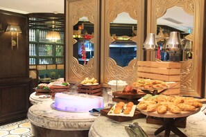 Un bufé con diferentes opciones de comida y una pieza central iluminada.