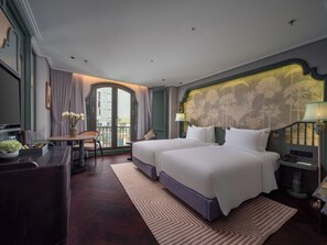 A hotel room with two beds, a desk, a chair, a view of the city, and a balcony. - Tonkin Luxury Boutique Hotel & Spa (Hanoi)