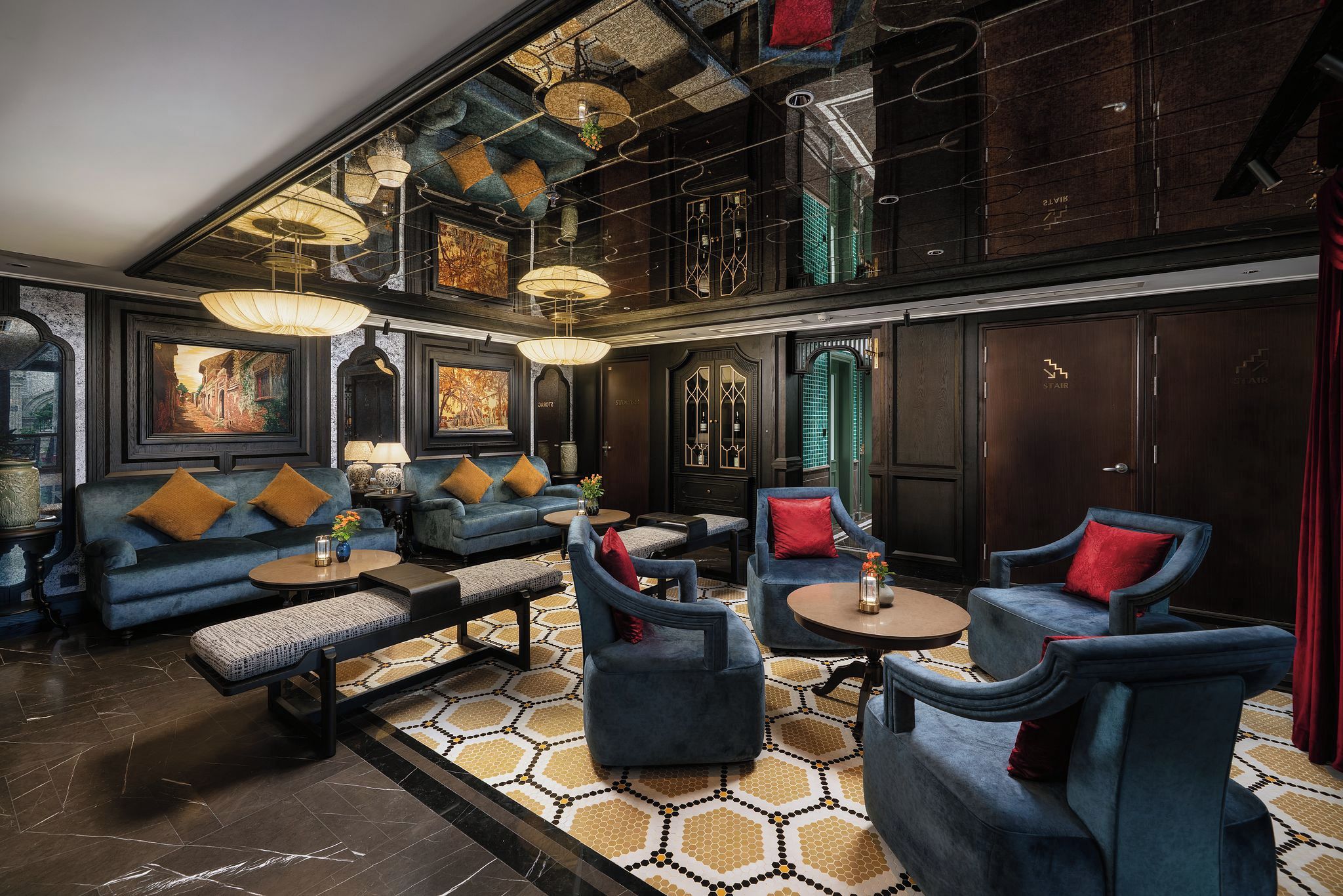 A spacious lounge with a high ceiling, multiple seating areas, and artwork on the walls.