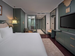 A hotel room with a large bed, a TV, a desk, and a chair. - Tonkin Luxury Boutique Hotel & Spa (Hanoi)