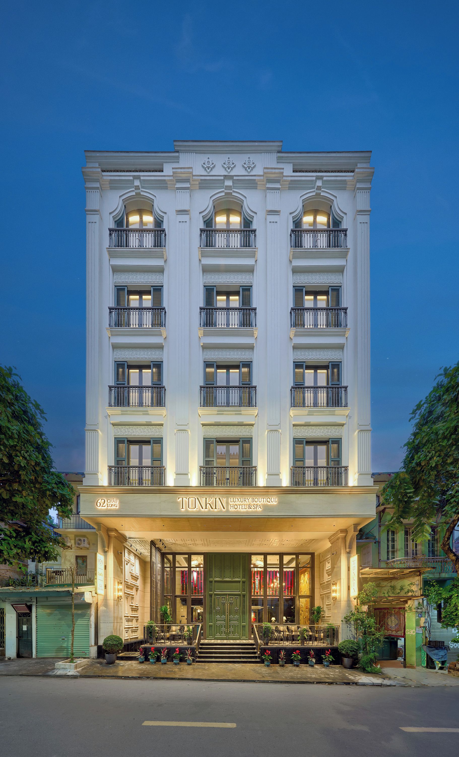 A multi-story building with a grand entrance, balconies, and a sign indicating it is a luxury boutique hotel and spa.