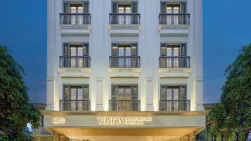 A multi-story building with a grand entrance, balconies, and a sign indicating it is a luxury boutique hotel and spa.