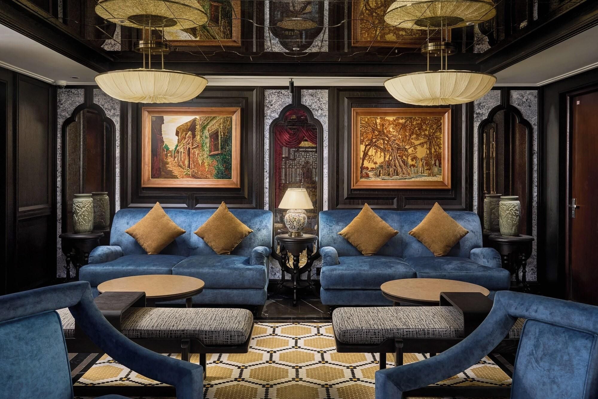 A room with two blue sofas, a patterned rug, and a round coffee table.