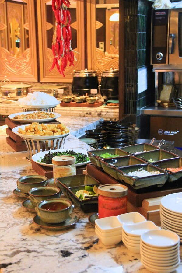 A buffet setup with various food items and condiments. - Tonkin Luxury Boutique Hotel & Spa (Hanoi)