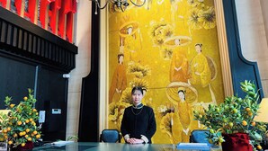 A reception desk with a large mural of traditional figures, a chandelier, and potted plants. - Tonkin Luxury Boutique Hotel & Spa (Hanoi)