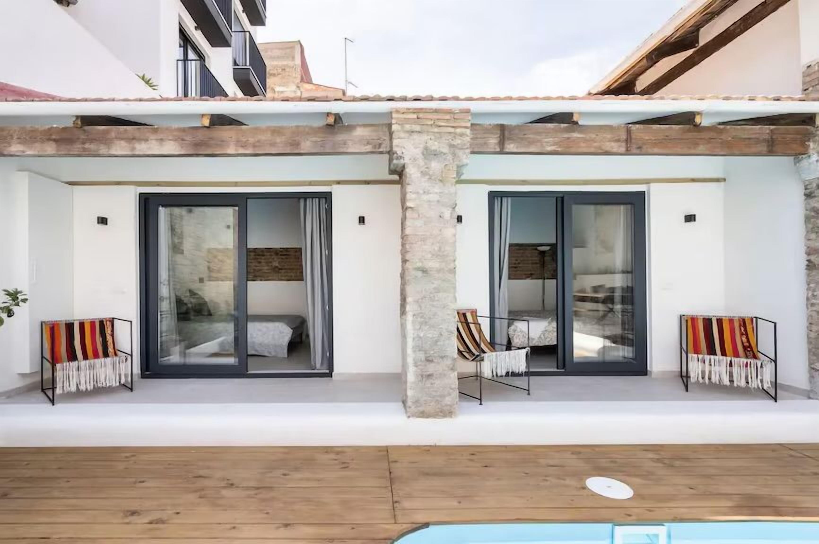Eine moderne Villa mit Pool, zwei Schlafzimmern mit Schiebegläsern und einer Holzterrasse.