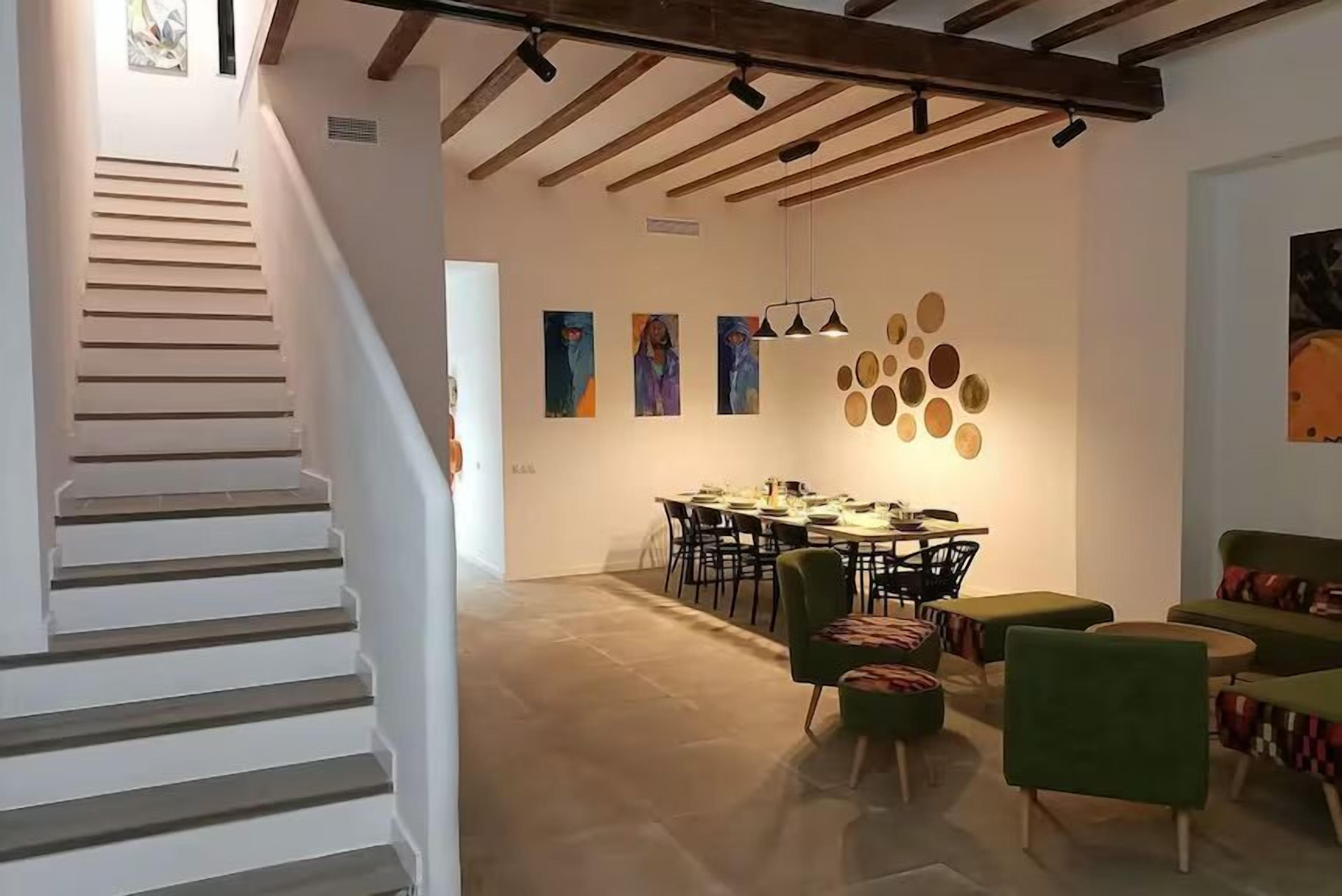 Un interior moderno con una escalera, comedor y zona de estar.