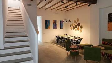 Un interior moderno con una escalera, comedor y zona de estar.