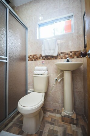 Ein Badezimmer mit Toilette, Waschbecken und Dusche.