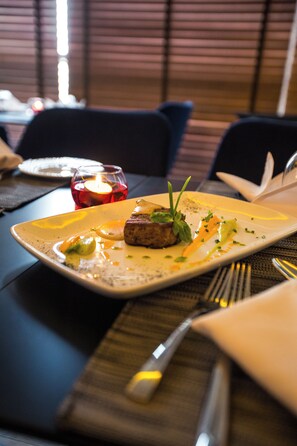 A dining table with a plate of food, a candle, and cutlery. - Sbn Suites Hotel (Tangier)