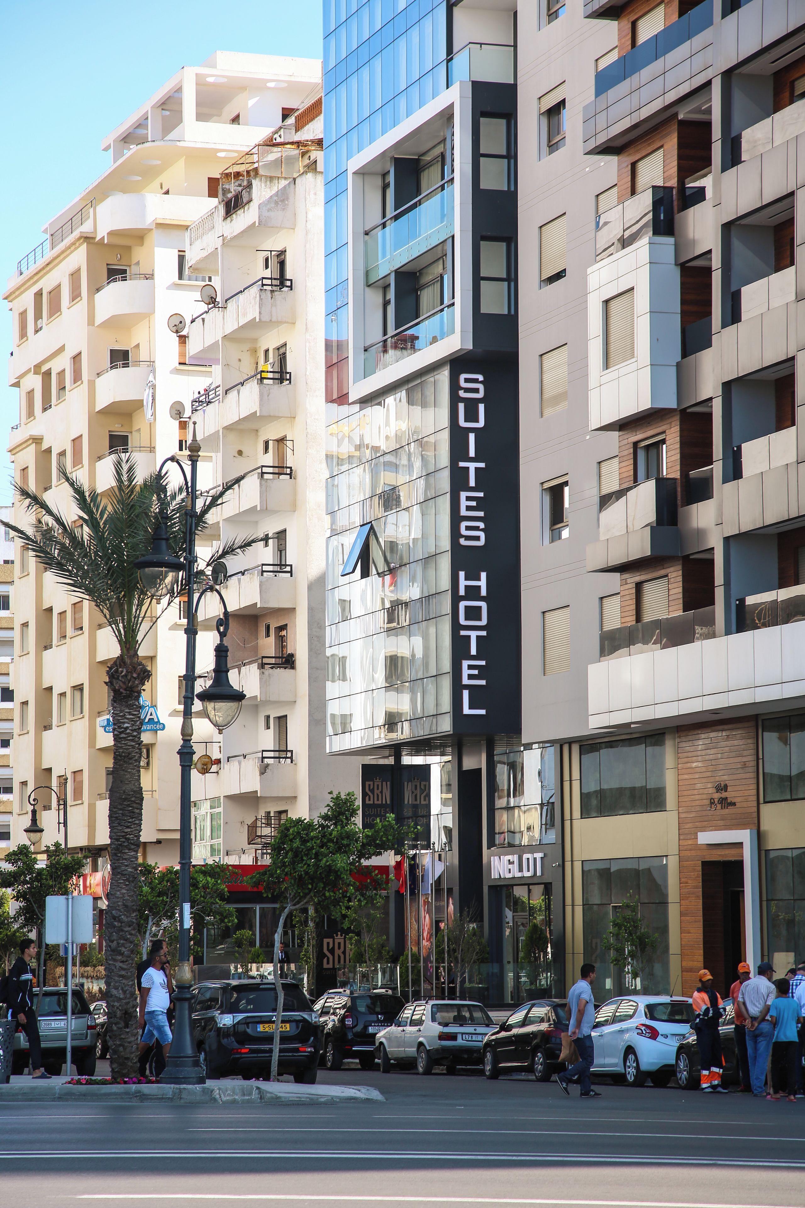 A hotel with a modern facade, balconies, and a visible sign for 'SQUITES HOTEL.'