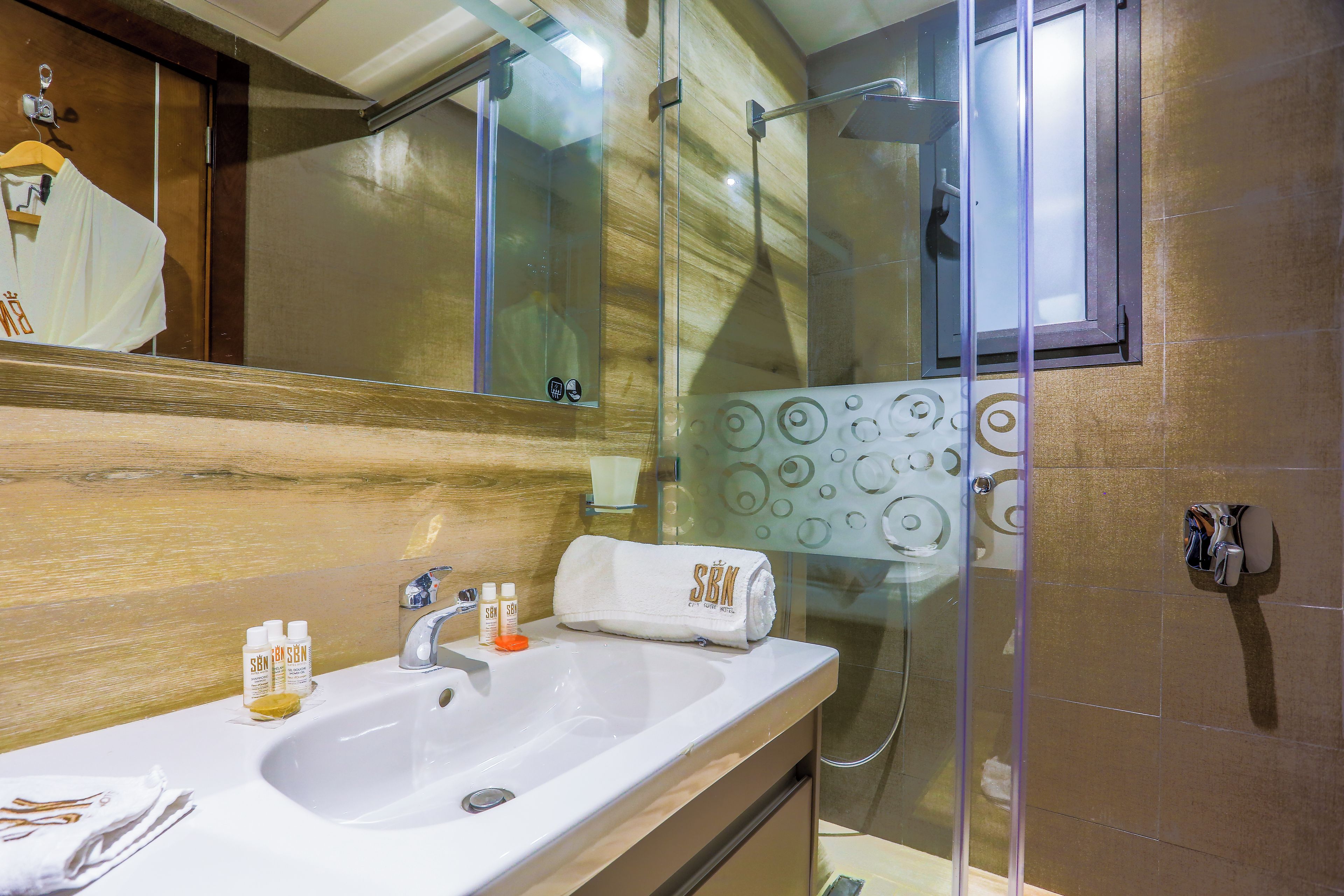 A bathroom with a sink, mirror, and glass shower enclosure.