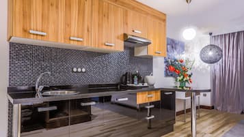 A modern kitchen with wooden cabinets, a black tiled backsplash, and stainless steel appliances.