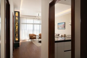 A modern living room with a chandelier, a sofa set, and a dining area with chairs. - Brassbell Sheikh Zayed Aeon Towers (6th of October City)
