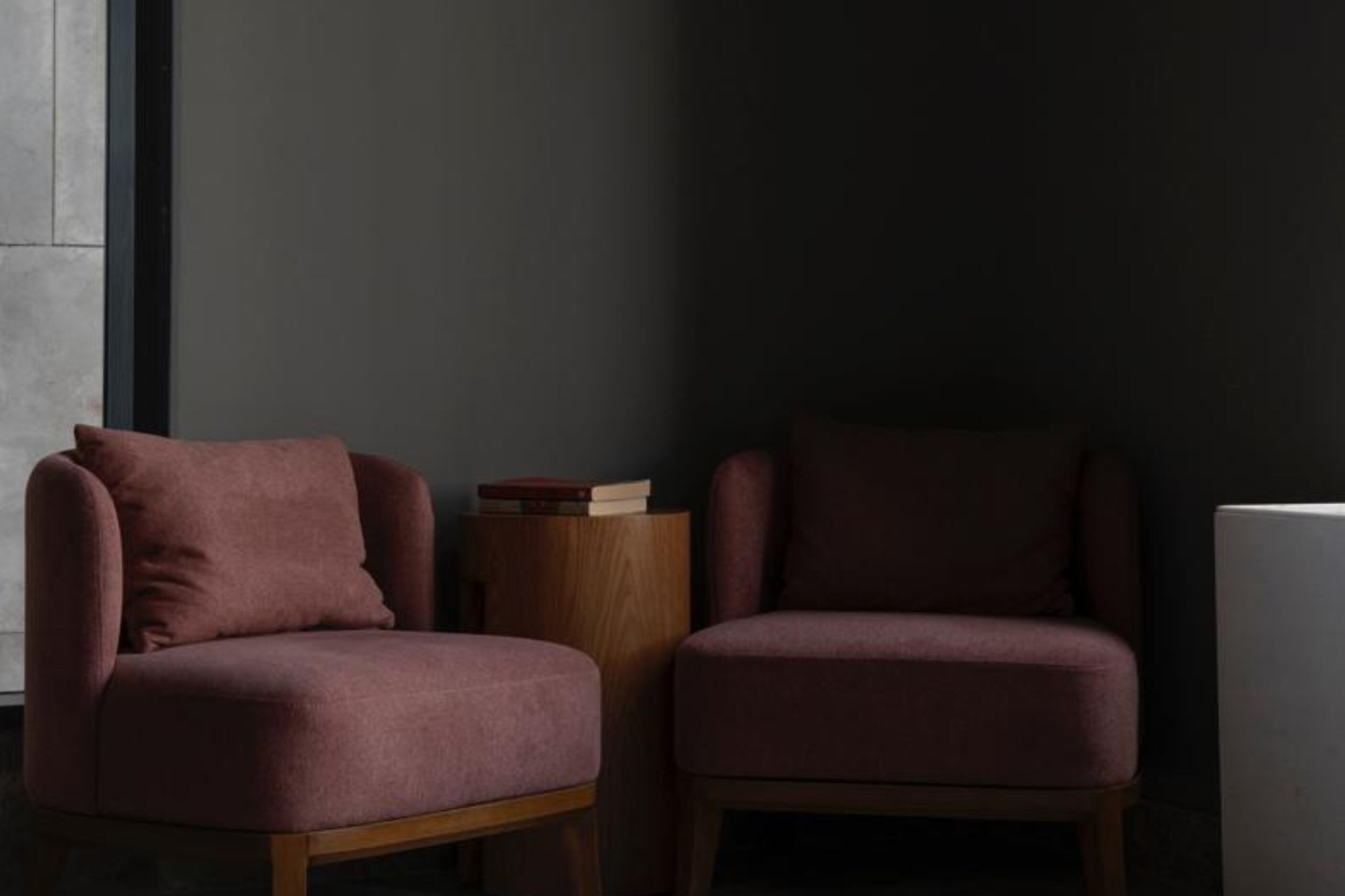 A room with two armchairs and a small wooden side table.