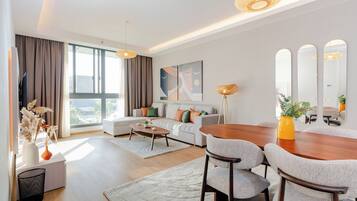 A modern living room with a sofa, coffee table, and dining table.