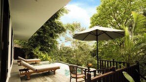 A pool area with lounge chairs, a wooden deck, and a view of dense greenery. - Leona Valley View Ubud (Ubud)