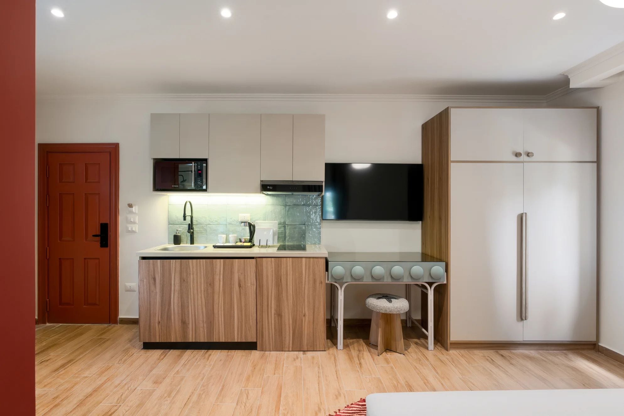 A modern kitchen with a built-in microwave, a stove, a sink, and a refrigerator.