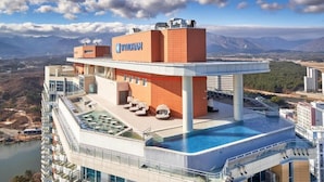 A high-rise hotel with a rooftop pool, a clear view of the mountains, and the WYNDHAM logo. - Wyndham Goseong Gangwon (Goseong)