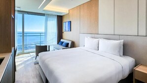 A modern hotel room with a large bed, a desk, and a view of the ocean. - Wyndham Goseong Gangwon (Goseong)