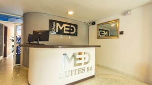 A reception desk with a sign reading "MED SUITES 94". - Suite 94 Hotel Baq (Barranquilla)