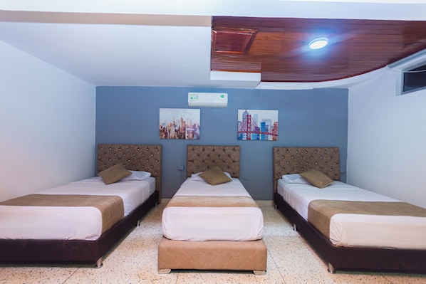 A hotel room with three beds, a ceiling fan, and two wall-mounted air conditioning units. - Suite 94 Hotel Baq (Barranquilla)