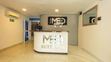 A reception desk with 'MED SUITES 94' signage, a mirror, and an emergency exit sign.