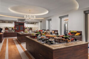 A modern kitchen with a large island, dark wood cabinetry, and a central chandelier. - Grandhotel Nabokov Spa & Wellness (Marianske Lazne)