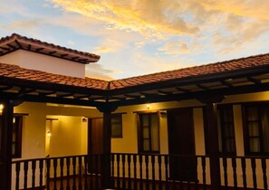 A building with a tiled roof and a balcony with a railing. - Hotel Calle Real (Villa de Leyva)