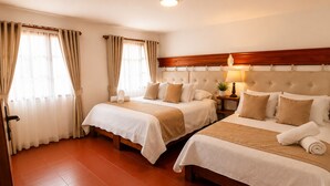 Ein Hotelzimmer mit zwei Betten, einem hölzernen Kopfteil, einem Nachttisch mit Lampe und einem Fenster mit Vorhängen.