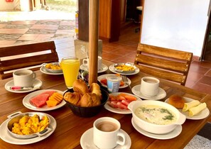 Ein Frühstückstisch mit verschiedenen Speisen, darunter Obst, Brot und Getränke.