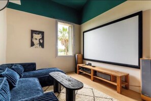 A room with a large screen, a sofa, a wooden bench, and a small table. - Villa Alexandre Dumas (Bussy-Saint-Georges)