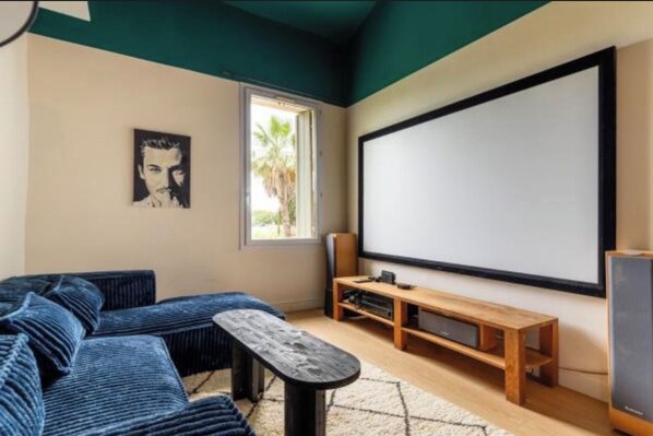 A room with a large screen, a sofa, a wooden bench, and a small table. - Villa Alexandre Dumas (Bussy-Saint-Georges)