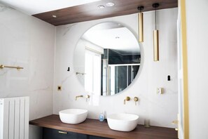 A modern bathroom with two white sinks, a large mirror, and gold fixtures. - Villa Alexandre Dumas (Bussy-Saint-Georges)
