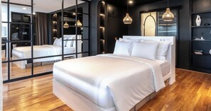 A modern bedroom with a large bed, mirrored closet doors, and pendant lighting. - Kiara Ocean Place (Tibubeneng)