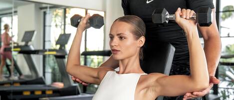 A gym with exercise equipment, including treadmills and dumbbells.