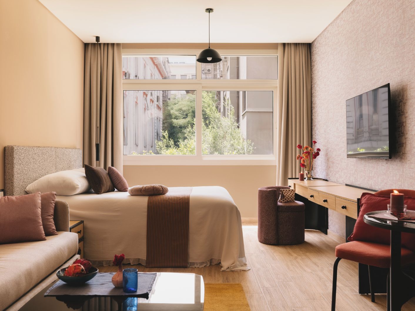 Une chambre d’hôtel moderne équipée d’un lit, d’un canapé, d’un bureau et d’une télévision.
