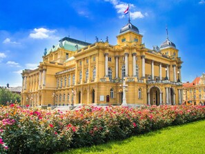 A large, historic building with a prominent dome and columns, surrounded by a well-maintained garden with colorful flowers. - Studio mitten im Zentrum von Zagreb by Interhome (Zagreb)