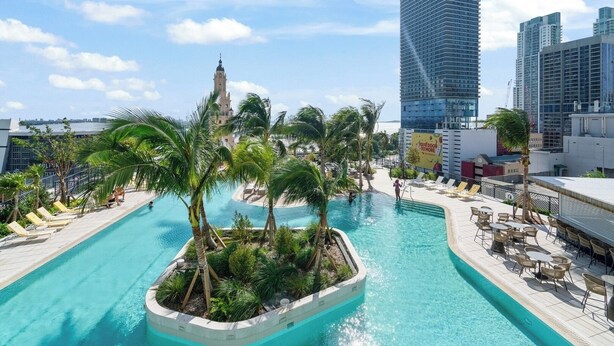 A rooftop pool with palm trees, lounge chairs, and a view of the city skyline. - Nice 2Bdrm Unit - Downtown Miami (Miami)