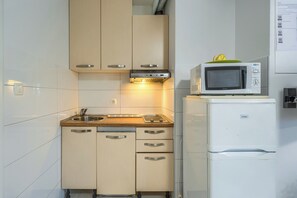 A compact kitchen with a microwave, a sink, and a refrigerator. - A comfortable apt w balcony, 4 min walk to beach (Split)