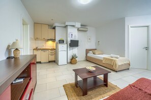 A compact living space with a kitchenette, a sofa, a small table, and a TV. - A comfortable apt w balcony, 4 min walk to beach (Split)
