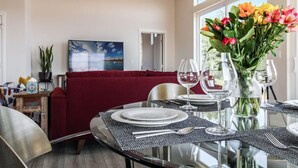 A dining area with a glass table, chairs, and a red cushioned bench. - The View House at Bryn Mawr Vineyards (Salem)