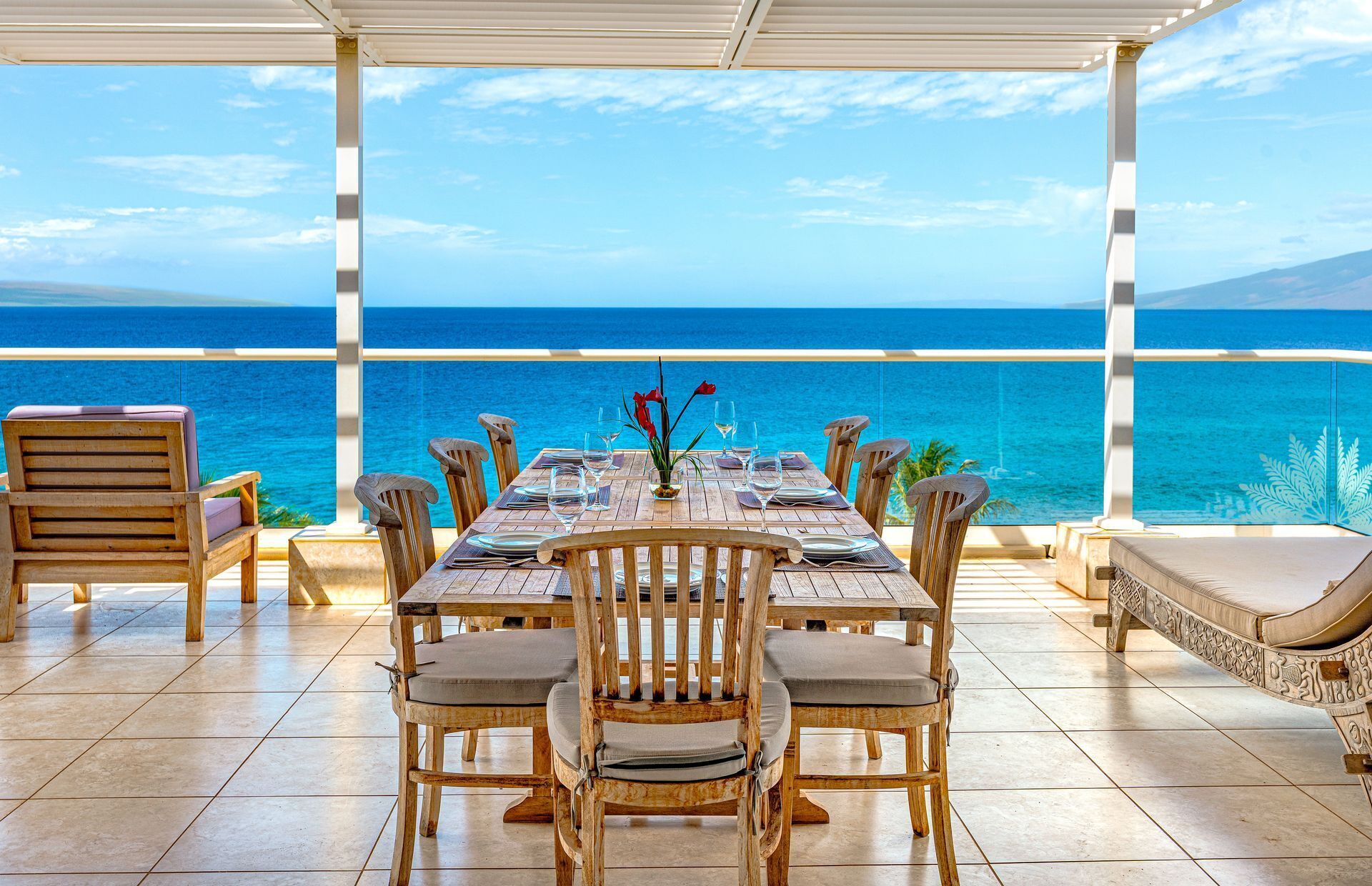 Mesa de madeira posta para refeição, com vista para o mar.