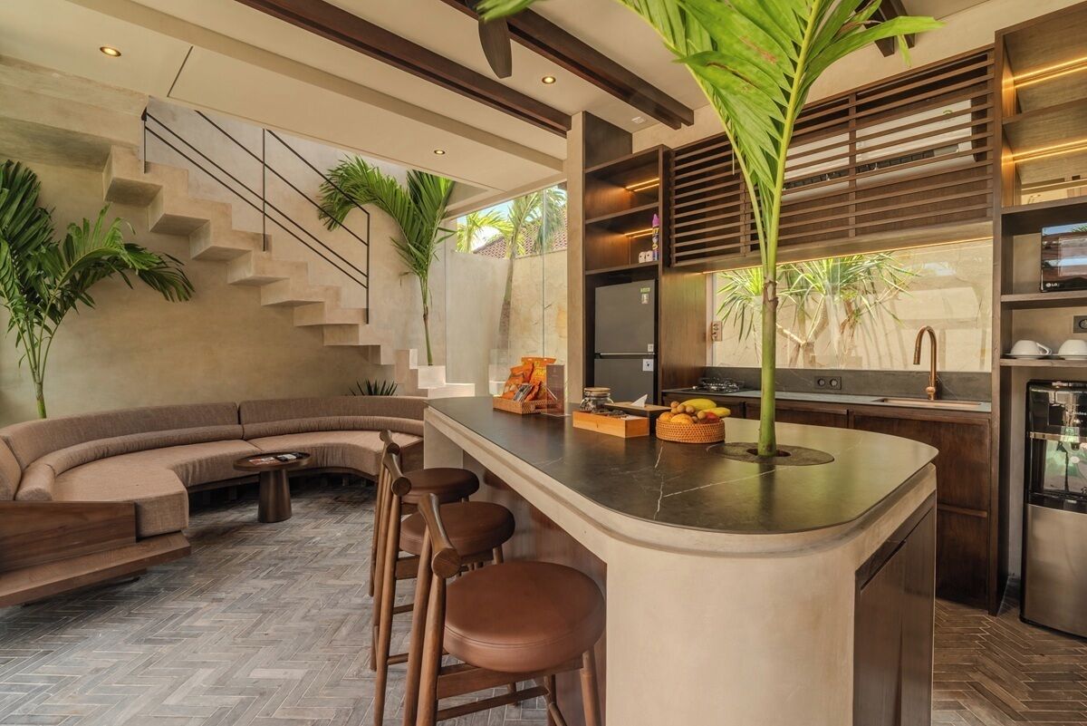 A modern kitchen with a central island, bar stools, and a built-in stove.